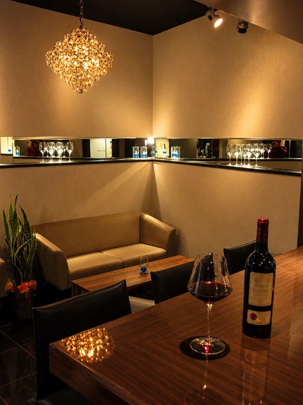 温かな照明に包まれたbar cabinのソファー席と木のテーブル